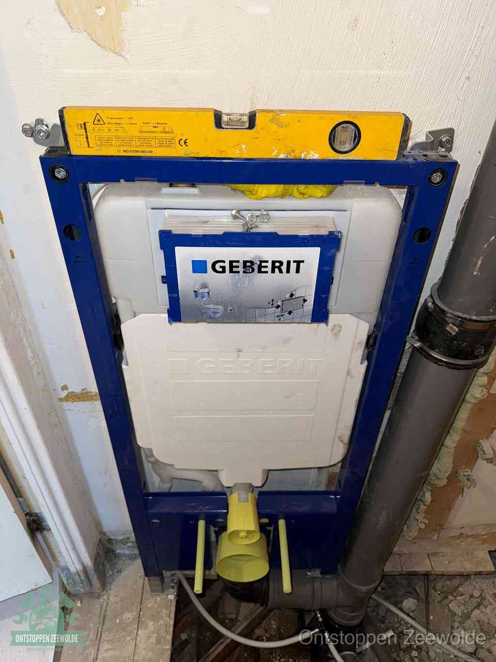 Een Geberit inbouwreservoir met frame voor een hangtoilet tegen de wand, met de afvoerbocht naar de vloer, kenmerkend voor een verstopt hangtoilet in Zeewolde
