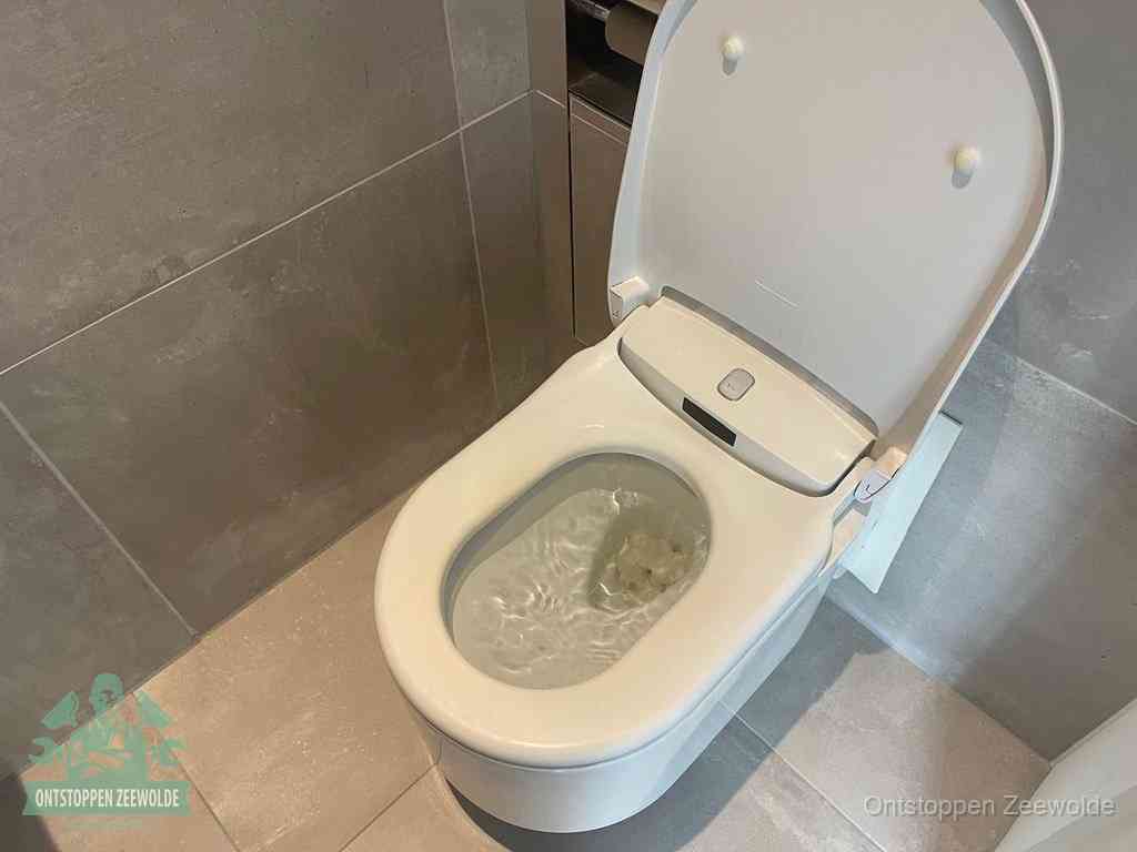 Een toiletpot vol troebel water met drijvend papier en restanten, de meest voorkomende oorzaak van een verstopte wc in Zeewolde