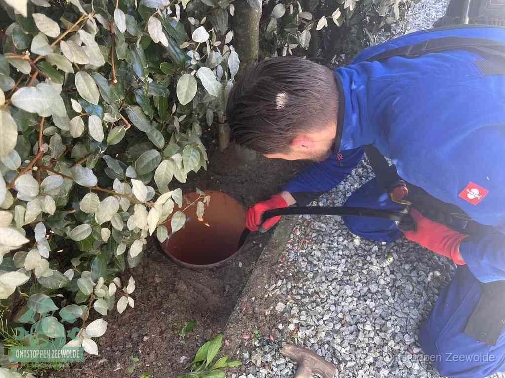 Monteur reinigt een rioolput met een slang, periodieke rioolreiniging in Zeewolde