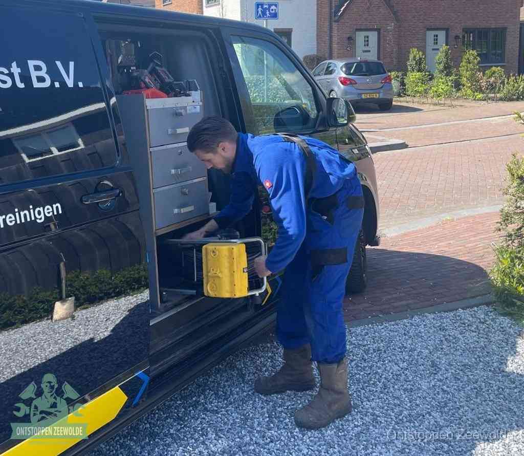 Een monteur pakt apparatuur uit de bedrijfsbus voor service aan huis, het moment om een professional in te schakelen voor een verstopte wc in Zeewolde
