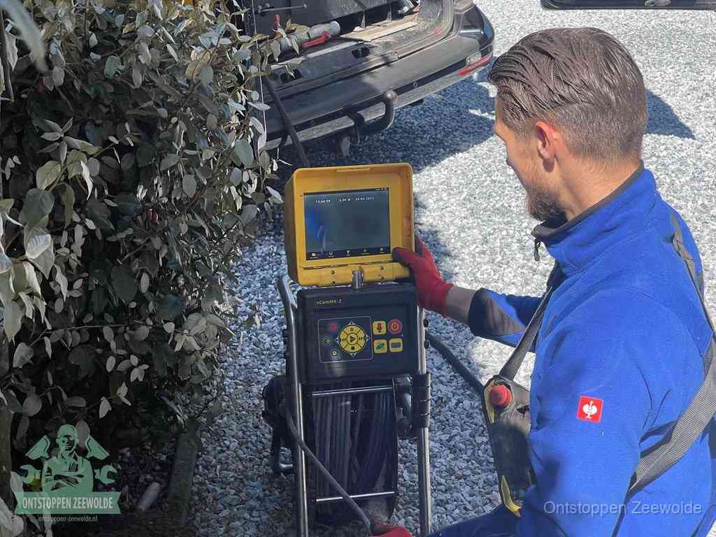 Monteur bedient een rioolinspectiecamera met monitor voor rioolinspectie in Zeewolde