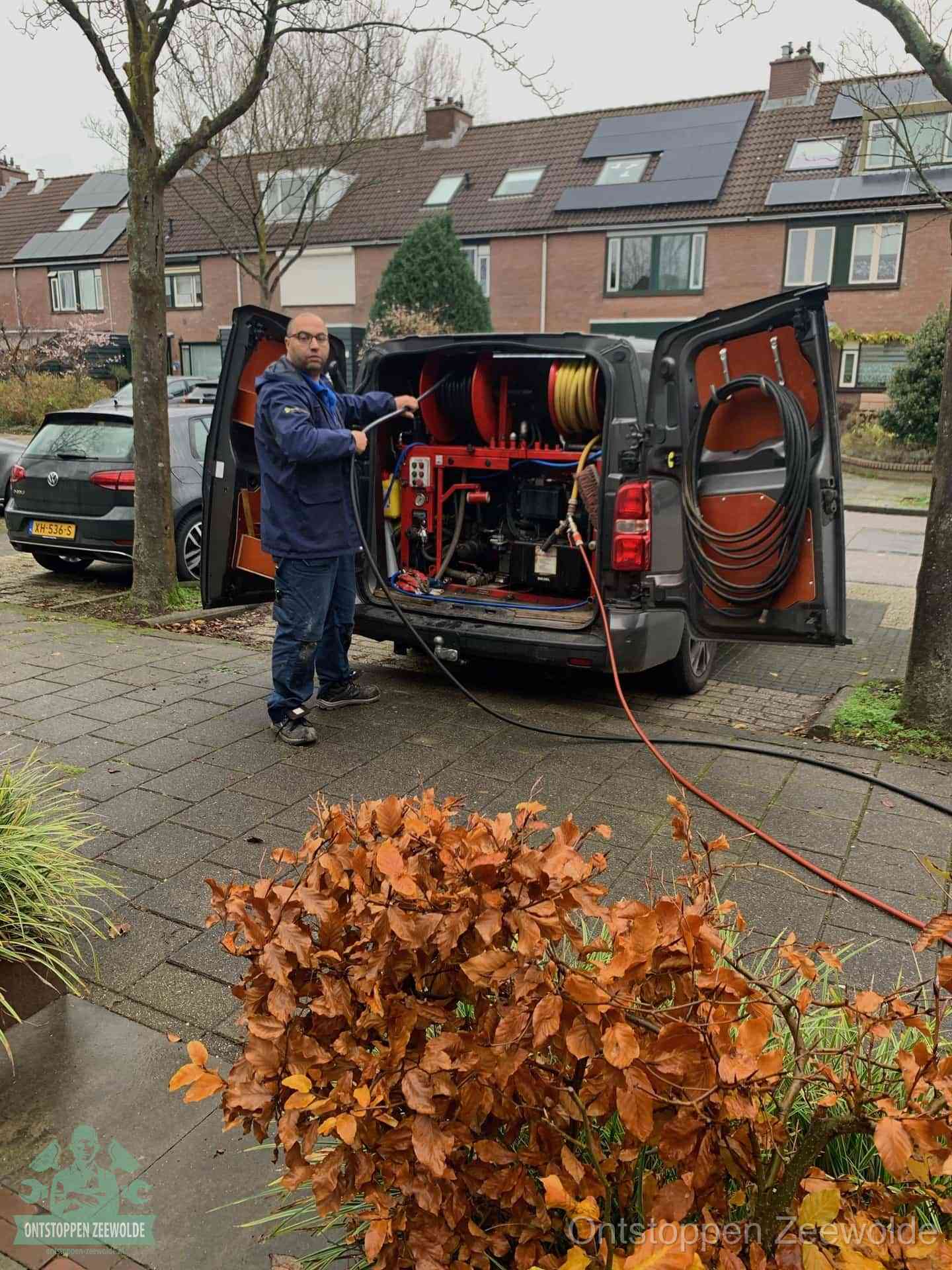 Monteur met rioolreinigingsbus levert rioolservice in de wijk in Zeewolde