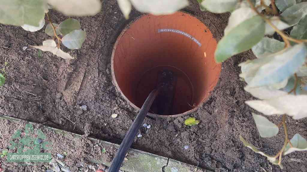 Open inspectieput in de tuin waar een veer rioolvliegjes en stankoverlast aanpakt in Zeewolde