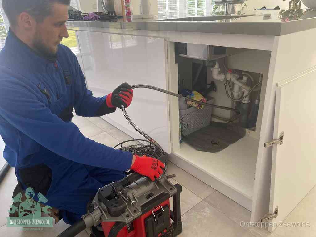 Een monteur reinigt de keukenafvoer grondig met een veermachine om terugkerende gootsteenverstoppingen te voorkomen in Zeewolde